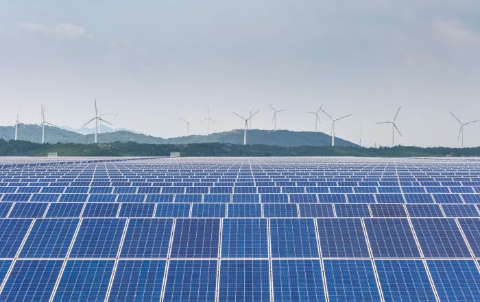 Parque solar con eólica al fondo